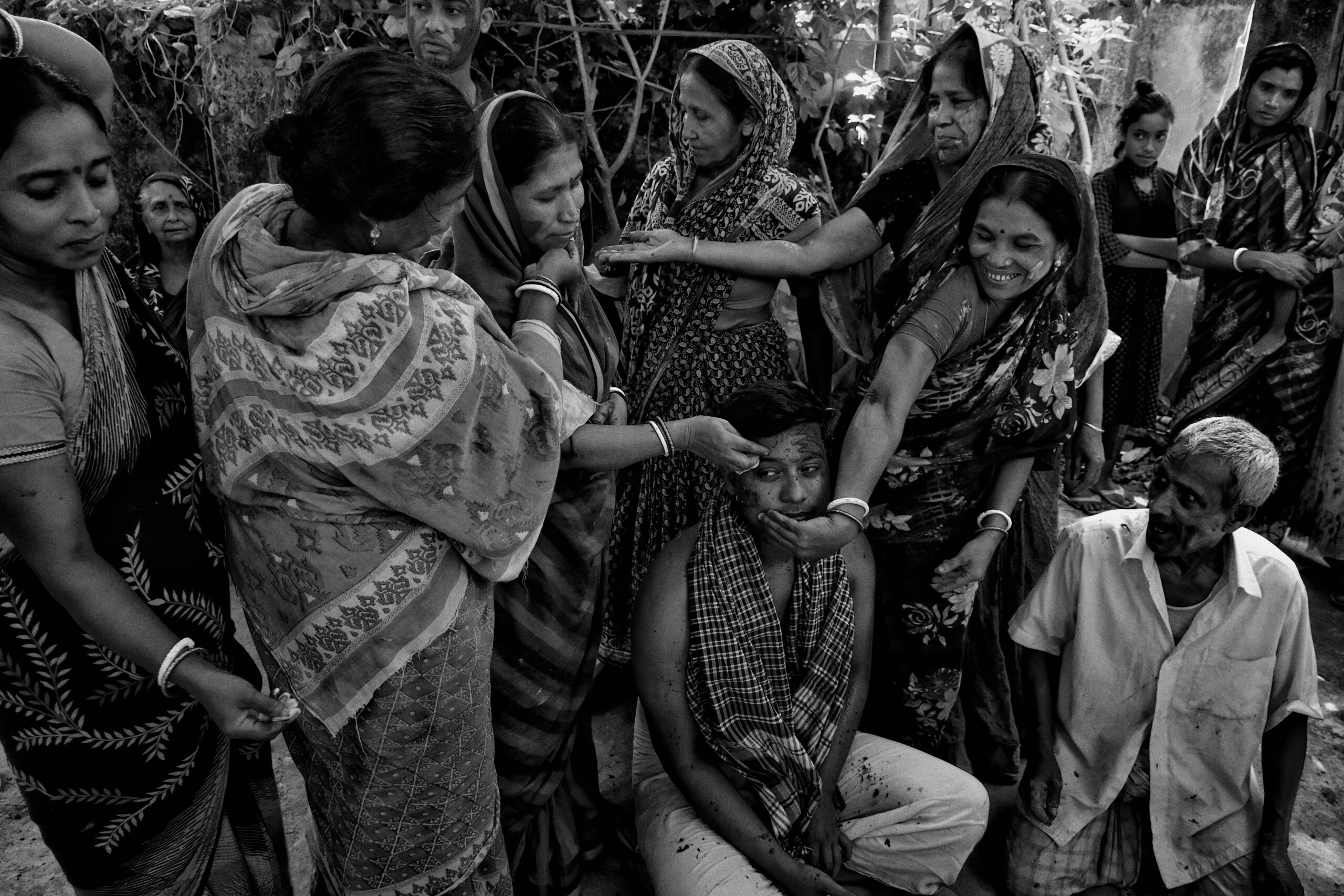 A black and white photo capturing a cultural Hindu ritual in a rural Indian village.